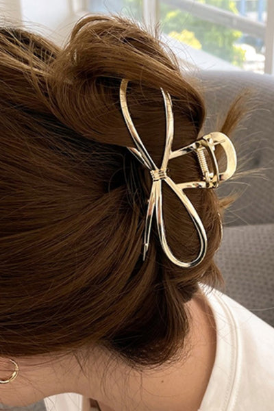 gold bow hair clip in hair in an updo